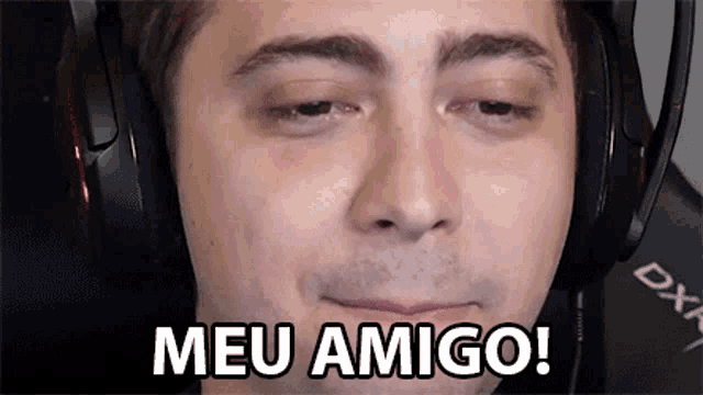a man wearing headphones is making a face and saying meu amigo !