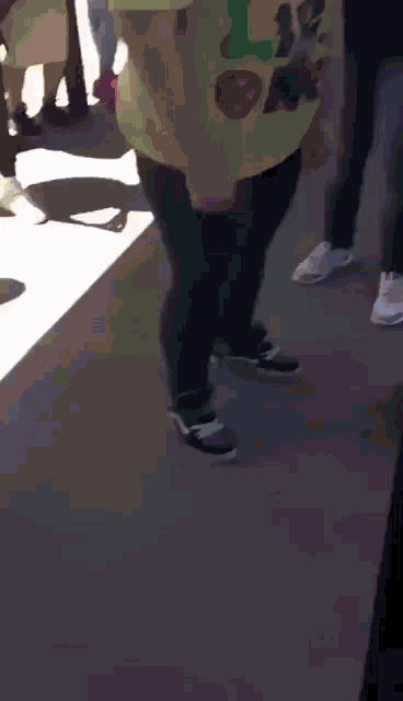 a person wearing a yellow t-shirt with a captain america logo on it