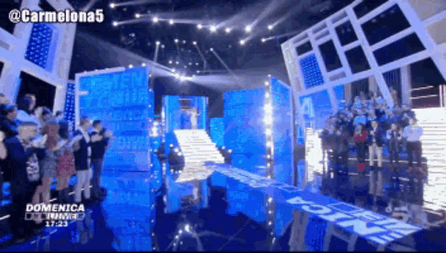 a group of people are standing on a stage with a sign that says domenica on it