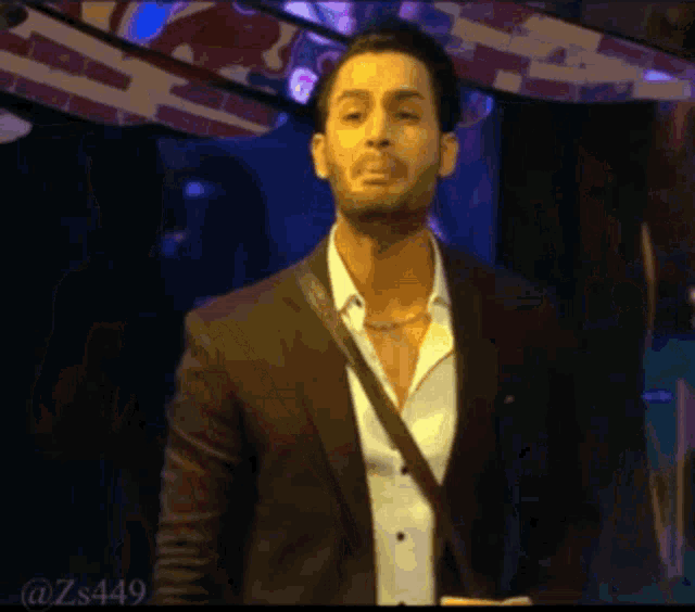 a man in a suit and white shirt is standing on a stage