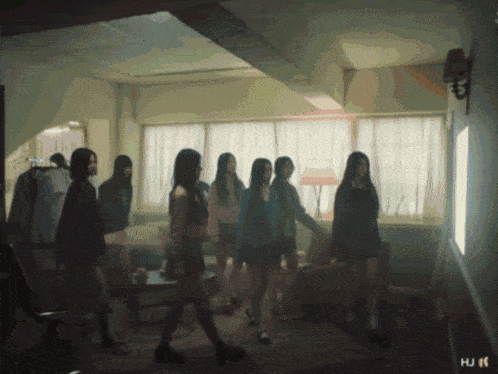 a group of girls are standing in a room with the letters hj on the bottom