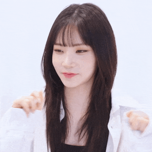 a woman with long dark hair and bangs is wearing a white shirt