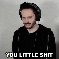 a man wearing headphones and a black hoodie is making a funny face and saying `` you little shit '' .