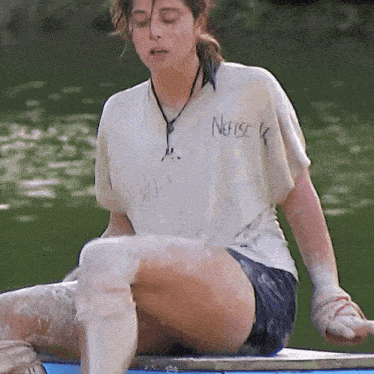 a woman wearing a white shirt that says nefise k on it