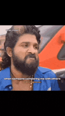 a man with a beard and curly hair is talking to someone .