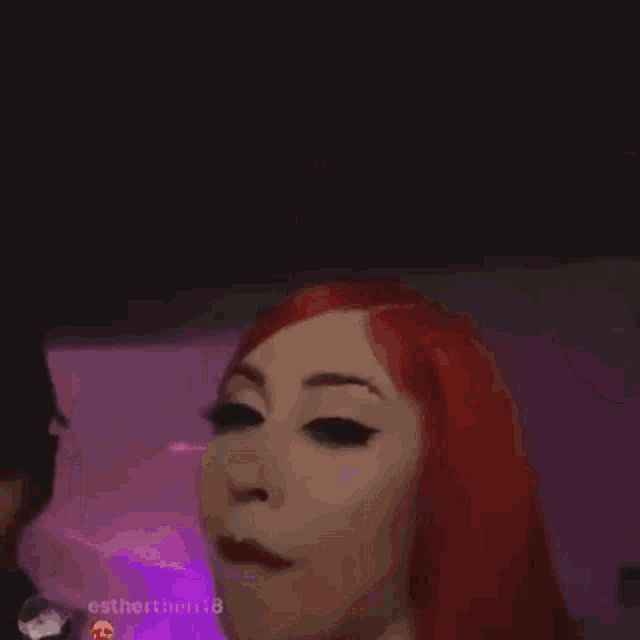 a woman with red hair is smiling in a blurry photo with omarxnyc written on the bottom