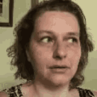 a close up of a woman 's face with a serious expression .
