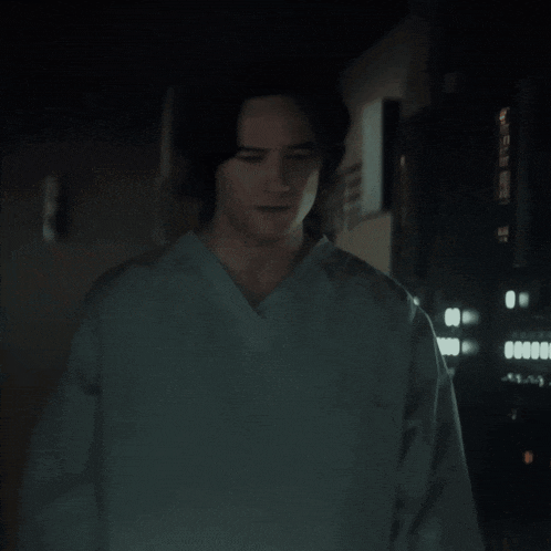a man in a scrub is standing in a dark room