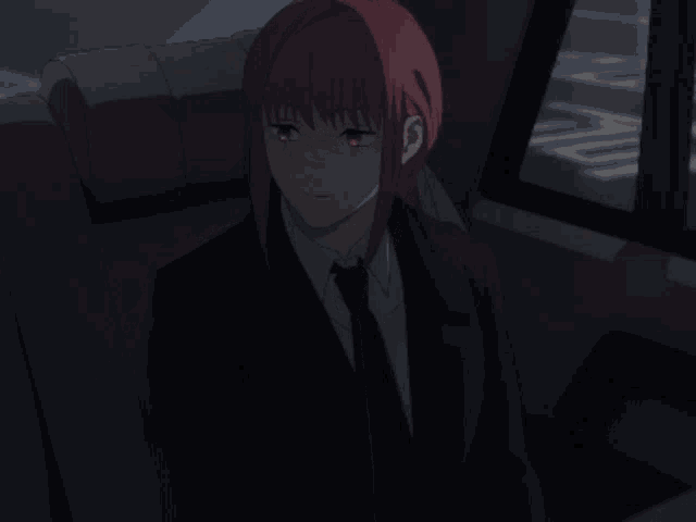 a woman with red hair is sitting in the back seat of a car with her eyes closed