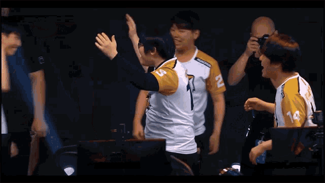 a man in a yellow and white jersey with the number 14 on it