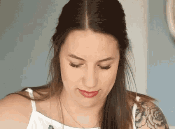 a woman with a tattoo on her arm is looking down at something