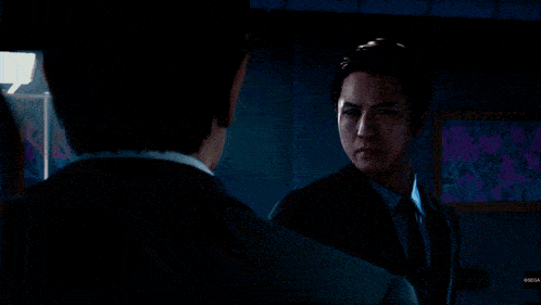 a man in a suit is holding a gun with the number 11 on the barrel