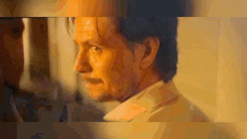 a close up of a man 's face with a yellow background .