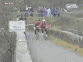 a blurry picture of people walking down a street with a sign that says ' i love you ' on it