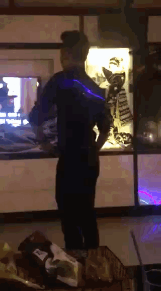 a man standing in front of a display case with a cat on it that says ' kitty ' on it