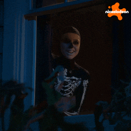 a woman in a skeleton costume is looking out a window with a nickelodeon logo in the background
