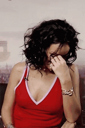 a woman in a red tank top is covering her face