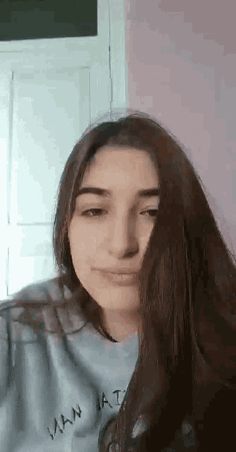 a woman with long hair is taking a selfie with her hair covering her face .