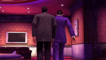 two men in purple suits are walking in a room
