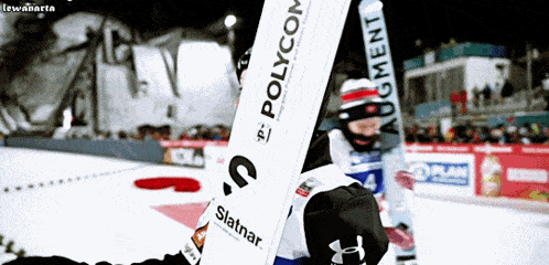 a person holding a snowboard that says " polycom " on it