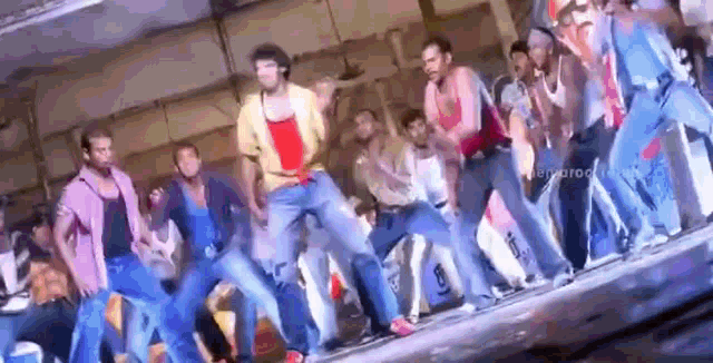 a group of men are dancing together on a stage in a room .