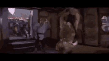 a group of people are standing in a room with a sword in their hand .