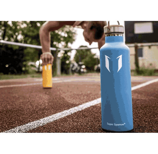 a blue super sparrow water bottle is sitting on a track