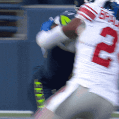 a football player with the number 22 on his jersey is being tackled by another player