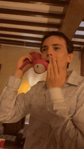 a man in a plaid shirt holds a pink object in his hand