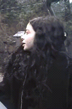 a close up of a woman 's face in a black coat