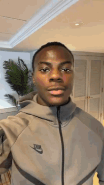 a man wearing a nike jacket is taking a selfie .