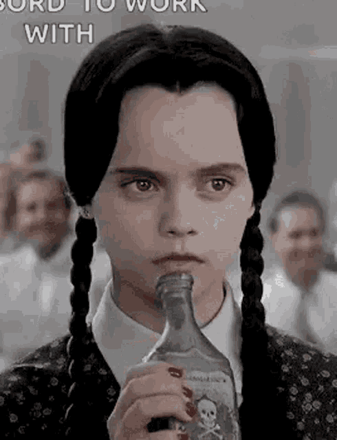 a girl with pigtails is holding a bottle of liquor in her mouth .