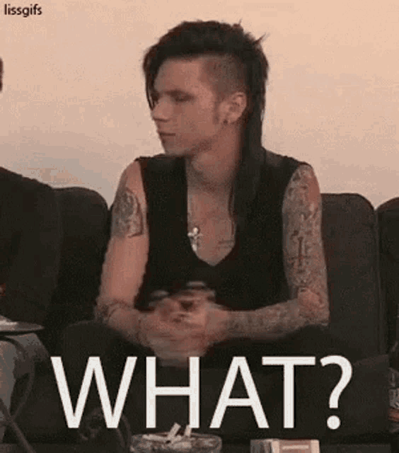 a man with a mohawk and tattoos is sitting on a couch and saying what ?
