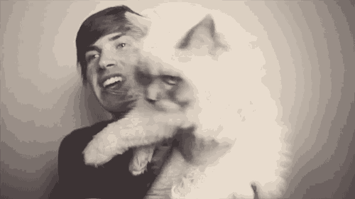 a black and white photo of a man and a cat