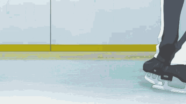a person 's feet are shown on a pair of black ice skates