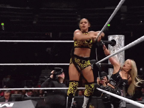 a woman in a wrestling ring holds a rope that says xo on it