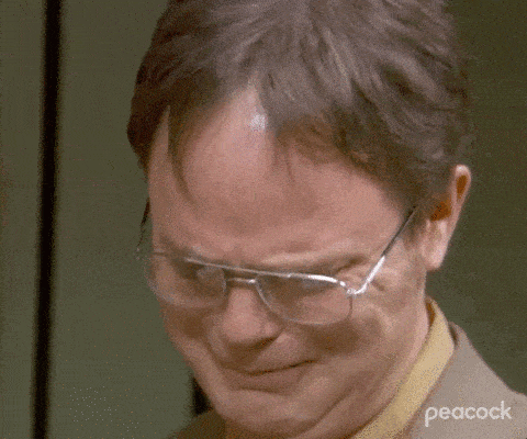 a close up of a man wearing glasses and a suit making a sad face .