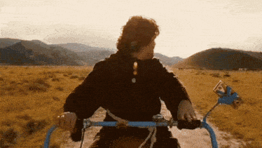 a man riding a bike on a dirt road