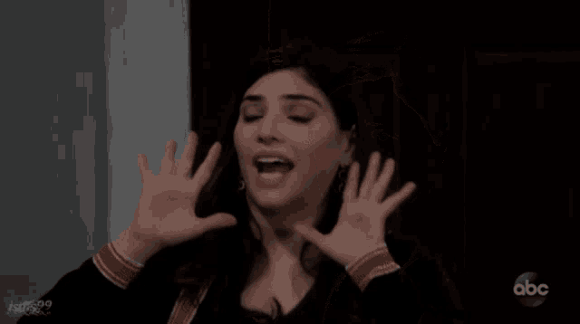 a woman with her hands in the air is on a abc show