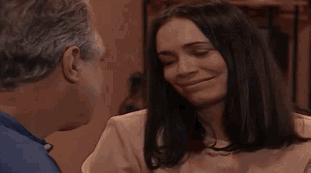 a man and a woman are kissing each other on the cheek .