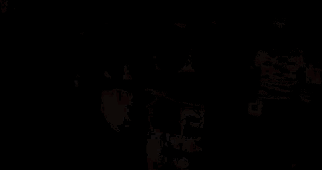 a man wearing a black shirt with a picture of a man on it stands in a crowd of people