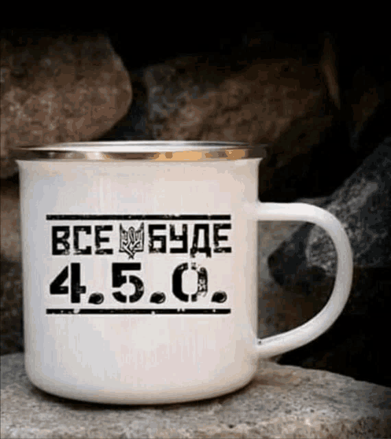 a white mug that says ' все буде ' on it