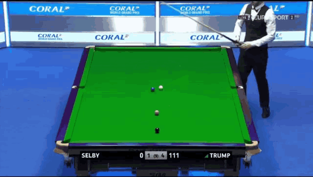 a snooker game is being played in front of a coral banner