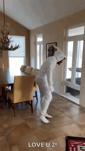 a person in a bunny costume is dancing in a living room with the words love u 2 on the floor