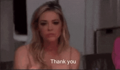 a woman is sitting on a couch and saying `` you 're welcome '' to someone .