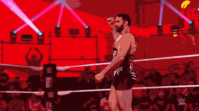 a man in a wrestling ring with a w logo on the corner