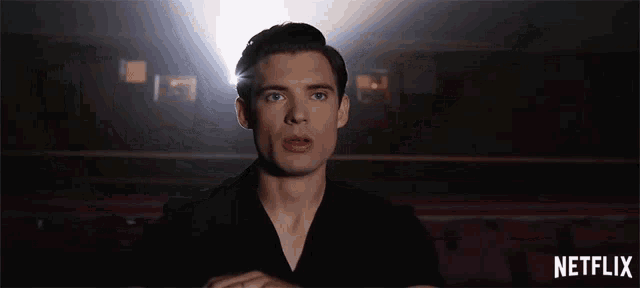 a man in a black shirt with a netflix logo in the corner