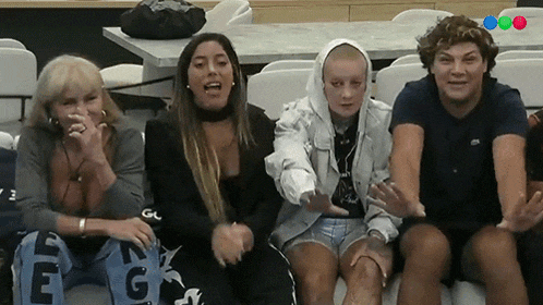a group of people are sitting on a couch and one of them has the letter e on her back