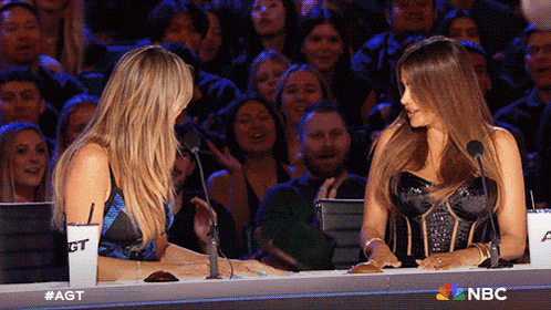 two women are sitting at a table with nbc written on the bottom