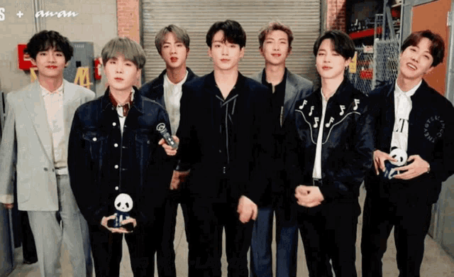 a group of young men standing next to each other with a sign that says s + aman on it